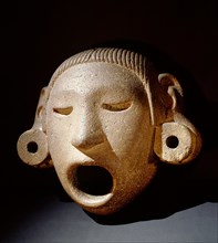 Open mouthed stone mask of Xipe Totec, the Flayed Lord, dressed in the skin of a sacrificial victim