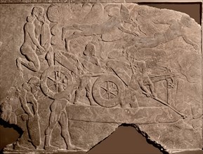Detail of a relief showing Assyrian troops crossing a river with a chariot on a float