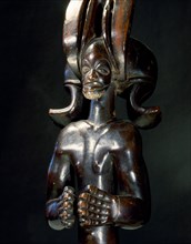 Wood figure of wearing headdress that is characteristic of Chokwe chiefs and also found on important masks