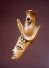 Wooden hunters whistle in the form of a mans head, decorated with imported brass furniture studs