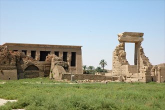 View of the Pro Pylon entrance to the Temple of Hathor courtyard with the facade of the Hypostyle Temple in the background and the remains of the mub brick enclosing wall onthe left