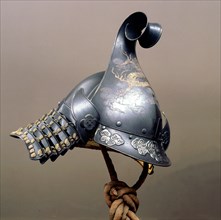 A nineteenth century helmet in the style of a late 16th century European brimmed helmet in lacquered iron with overlay design of clouds and dragons in gold and silver