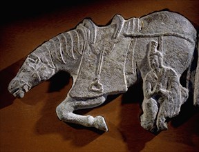 A fragment of a relief of a horse and attendant