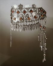A silver headband inlaid with red precious stones