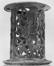 A bronze stand that incorporates the images of a warrior