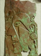 Face, possibly a portrait of a prominent warrior, embossed in copper