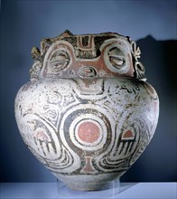 Funerary urn painted with a stylized representation of a crouching female fertility deity