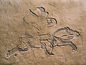 A brick from a tomb structure with a design of a warrior executing a Parthian shot whilst riding his galloping horse