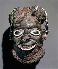 The beard and raffia cap depicted on this mask headdress indicate that an important titled man is represented