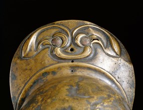 Detail of the peak of a bronze helmet