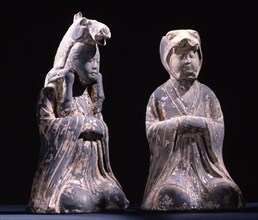 Two male kneeling figures representing animals of the zodiac