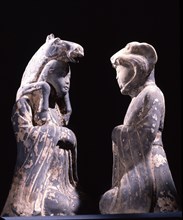 Two male kneeling figures representing animals of the zodiac
