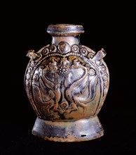 A molded brown glazed flask decorated on one side with a pair of birds surrounded by flowerheads