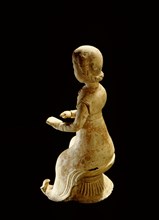 Figure of a seated woman reading a book