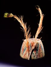 Fez style hat of coloured and twisted llama threads looped into coils, with triangular and step volute design