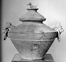 A ritual vessel with a bird shaped lid handle
