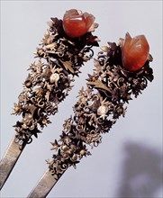 Detail of a pair of hairpins made from gold and cornelians