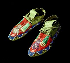 Pair of quilted mocassins decorated with beadwork and quillwork in a design of bear claws and buffalo heads