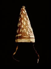 Conical hat worn by women over a topknot hairstyle