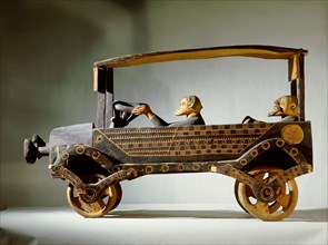 A wooden carving of a car with a European and his driver