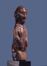 A Kongo ivory carving depicting a European man holding a bottle