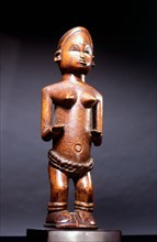 Small wood figure with inset ivory eyes, showing female scarification patterns