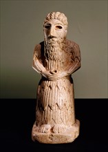 Seated votive figure of man holding a cup in his hands