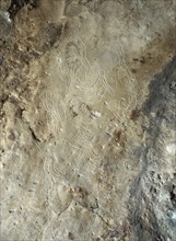 Images of male human figures engraved in limestone walls of the cave at Addaura