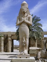 A colossal statue of Ramesses II with a princess, perhaps his daughter Bentanta, standing between his feet