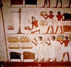 A detail of a wall painting in the tomb of Panekhmen depicting metal workers weighing gold on scales