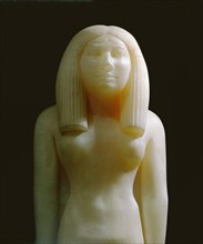 An alabaster statue of a woman wearing a heavy wig
