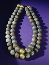 Necklace of double strands of lapis lazuli beads, with gold clasp and two gold beads at centre