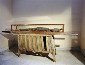 Mummified crocodile on a bier resting on a wooden supporting structure