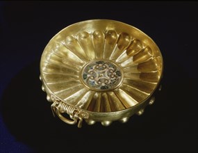 Fluted gold bowl with inset faience centre disk, inlaid with four stylised palmettes
