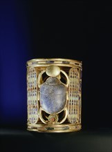 Gold bracelet from the tomb of Amenemope mounted with a lapis lazuli scarab bearing aloft the gold solar disc