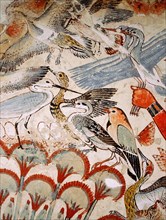 A detail of a painting from the tomb of Nebamun showing him standing on a reed boat hunting birds in the papyrus marshes using throwsticks and three decoy herons