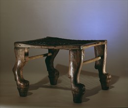 A wooden stool with legs carved in the form of lions paws