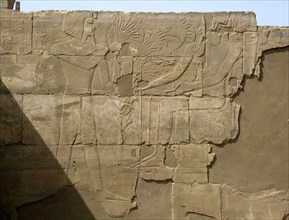Relief from the walls behind the processional colonnade of Amenophis III depicting Tutankhamun offering flowers to a seated deity