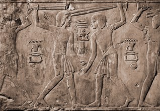 Relief from the tomb of Kharuef of young men in light tunics stick fighting