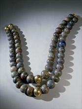 Necklace of double strands of lapis lazuli beads, with gold clasp and two gold beads at centre