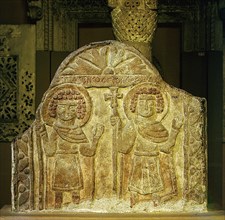 Limestone relief depicting a pair of saints holding the cross