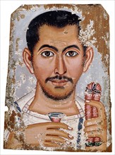 Portrait of a man holding a small glass vessel and garland