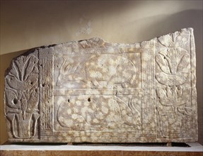 Relief carving depicting two bound oxen, flanked by rows of lotus flowers