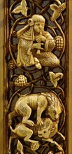 A detail of an ivory inlay from a piece of furniture depicting a lion attacking a deer