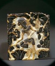 An ivory panel from a box with a depiction of an Amarna princess picking lotus flowers and grapes