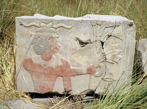 Block from a painted relief depicting a king with a rams horn headdress presenting an offering of flowers