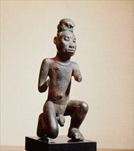 Kneeling figure of a man, with medicinal substances attached to head