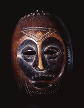 A mask which is not worn but is manipulated and used as a mnemonic device linked with proverbs recited during the initiation rites of the senior grades of the Lega Bwami society