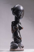 Wooden figure of Luba woman, served as a prestige possesion of a chief or king, illustrating the social and political importance of royal women in Luba society