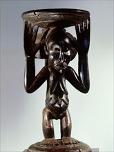 Stool or bowl supported by standing woman